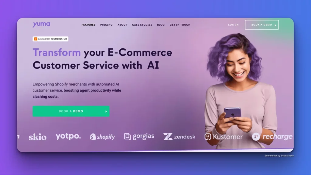 A woman with purple hair smiling while using a phone against a gradient purple background. The text reads, "Transform your E-Commerce Customer Service with AI Customer Support Software" and includes various logos and a CTA button "Book a Demo." The website navigation bar is at the top.